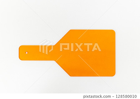 A Bright Orange Paddle Tool Against a White Background: Practical Uses in Various Applications Including Cooking, Art, and Educational Settings 128580010