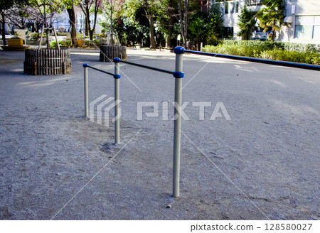 A scene of a horizontal bar in a large, empty park 128580027