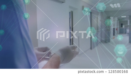 Adult doctor is adjusting latex gloves in 2D design hospital ward, with floating health icons 128580168