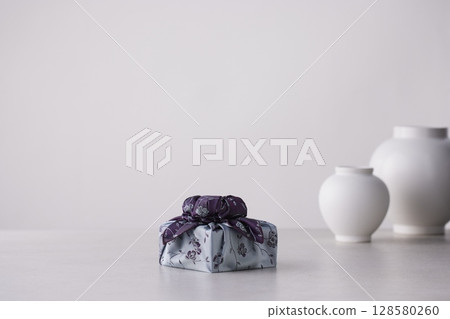 Elegant Korean table setting with traditional Korean bojagi gift wrapping for Chuseok, ceramic vase and fabric, tree branches. Elegant Korean table setting with traditional Korean bojagi gift wrapping for Chuseok, ceramic vase and fabric, tree branches. 128580260