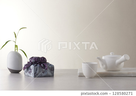 Elegant Korean table setting with traditional Korean bojagi gift wrapping for Chuseok, ceramic vase and fabric, tree branches. 128580271