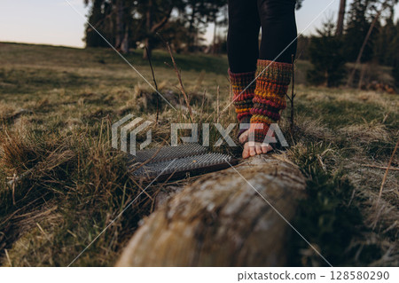 Bare feet in knitted leg warmers standing on nails over grass, symbolizing yoga practice, meditation, pain tolerance, and overcoming fear. A powerful image of mental strength and body awareness Bare feet in knitted leg warmers standing on nails over grass, symbolizing yoga practice, meditation, pain tolerance, and overcoming fear. A powerful image of mental strength and body awareness 128580290