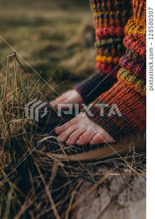 Bare feet in knitted leg warmers standing on nails over grass, symbolizing yoga practice, meditation, pain tolerance, and overcoming fear. A powerful image of mental strength and body awareness Bare feet in knitted leg warmers standing on nails over grass, symbolizing yoga practice, meditation, pain tolerance, and overcoming fear. A powerful image of mental strength and body awareness 128580307