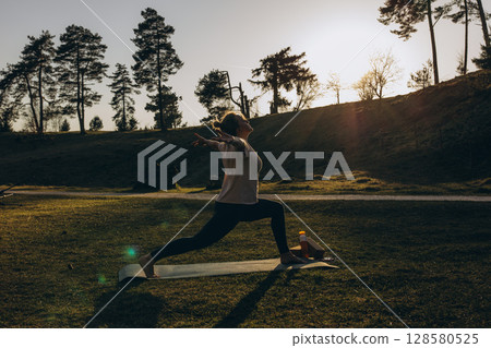 Young woman doing yoga outdoors,meditating in nature. Healthy lifestyle, strength, calm, mindfulness 128580525