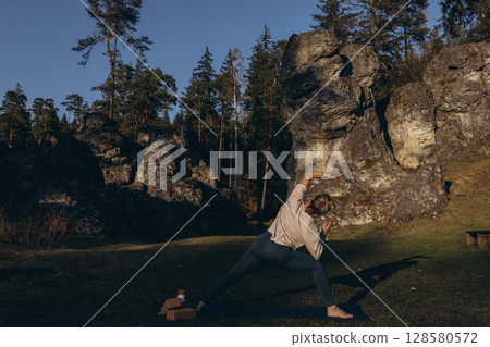Young woman doing yoga outdoors,meditating in nature. Healthy lifestyle, strength, calm, mindfulness Young woman doing yoga outdoors,meditating in nature. Healthy lifestyle, strength, calm, mindfulness 128580572