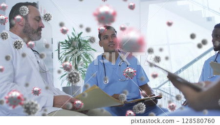 Diverse medical team reviewing files and discussing pandemic response in clinic with virus overlays 128580760