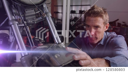 Image of glowing lights over caucasian male mechanic repairing motorbike in garage 128580803
