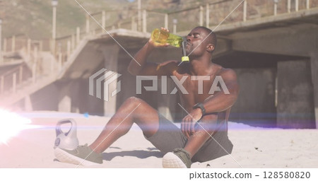 Image of glowing lights over an exercising african american man drinking water 128580820