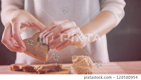 Image of hearts over hands of caucasian woman holding cookies Image of hearts over hands of caucasian woman holding cookies 128580954