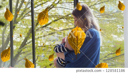 Image of leaves over caucasian mother feeding baby in park Image of leaves over caucasian mother feeding baby in park 128581186