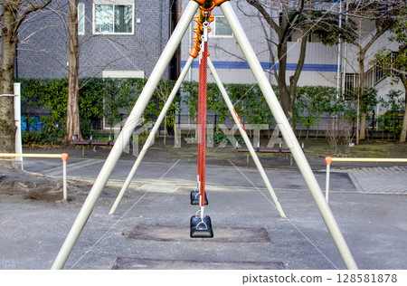 Scenery of a swing set in a large, empty park Scenery of a swing set in a large, empty park 128581878
