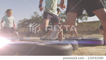 Image of light spots over diverse schoolchildren exercising on obstacle course 128582080