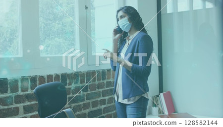 Image of glowing light over biracial businessman using technology 128582144