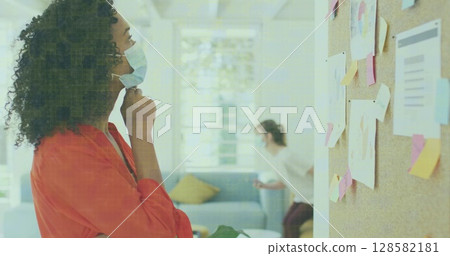 Image of data processing over businesswomen wearing face masks 128582181