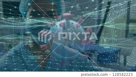 Researcher inspecting 3D virus model with spike proteins in lab, with network data overlay 128582223