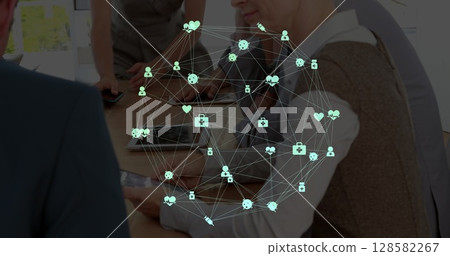 Image of network of connections with icons over diverse businesspeople in office Image of network of connections with icons over diverse businesspeople in office 128582267