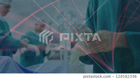 Scrub staff member tying on sterile gloves in operating room, with digital overlay and lights 128582336
