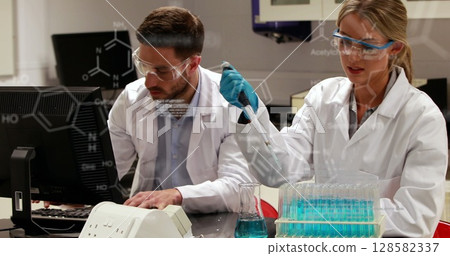 Image of scientific data over caucasian female and male lab workers with samples Image of scientific data over caucasian female and male lab workers with samples 128582337