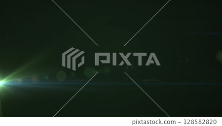 Image of glowing green light moving on dark green background 128582820