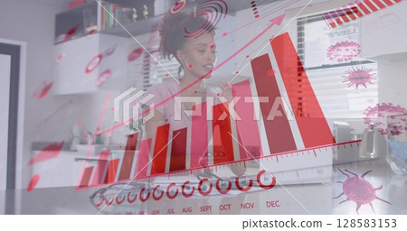 Image of virus cells and graphs over biracial woman working from home 128583153