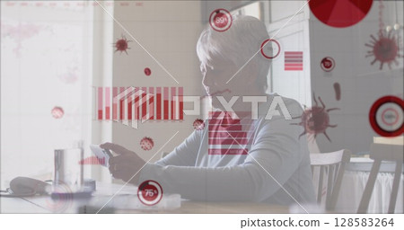Holding smartphone senior woman sitting at kitchen dining table, with digital graphic overlays Holding smartphone senior woman sitting at kitchen dining table, with digital graphic overlays 128583264