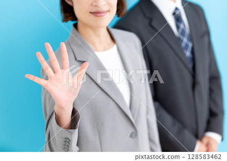 一位中年女商人和一位身穿灰色西裝的男商人舉起五根手指 128583462