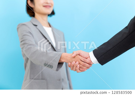 一位中年女商人和一位西裝革履的男商人握手 128583500