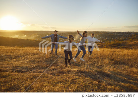 Happy family nature outdoor running like plane, spending weekend holiday together 128583697