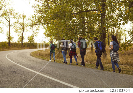 Group of friends tourists trekking with backpacks walking in the forest. Group of friends tourists trekking with backpacks walking in the forest. 128583704
