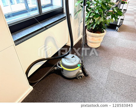 Vacuum cleaner on gray floor in the office Vacuum cleaner on gray floor in the office 128583843