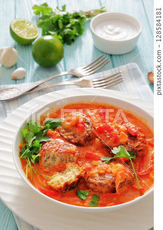 fish cakes in tomato vegetable coconut milk sauce 128584181