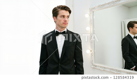 Man in tuxedo reflecting in mirror Man in tuxedo reflecting in mirror 128584319