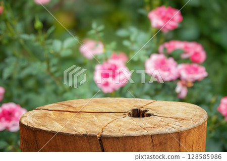 Empty old tree stump table top with blur rose garden background for product display 128585986