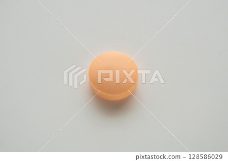 Orange medicine pill tablet on white background Orange medicine pill tablet on white background 128586029