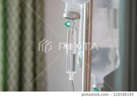 Close up medical intravenous IV drip in hospital background 128586193