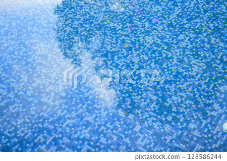 Swimming pool water surface and ripple wave with blue mosaic tiles Swimming pool water surface and ripple wave with blue mosaic tiles 128586244
