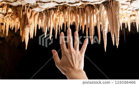 Hand Touching Cave Stalactites 128586466