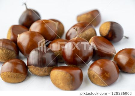 Shiny and round chestnuts ripened in autumn 128586903