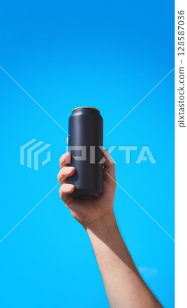 Black drink can held in hand for mockup with blue sky background for beverage branding 128587036