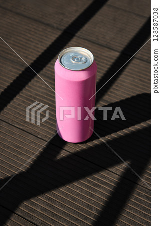 Pink soda can mockup on dark wooden floor with dramatic shadows Pink soda can mockup on dark wooden floor with dramatic shadows 128587038
