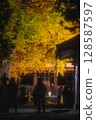 Illuminated autumn leaves and worshippers 128587597