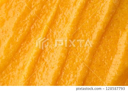 The texture of a orange body scrub with particles. Close-up 128587793