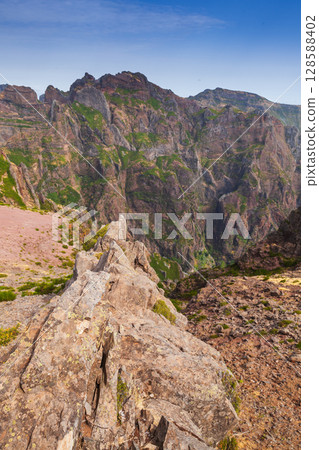 Scenic view of a rugged mountain range with vibrant greenery 128588402