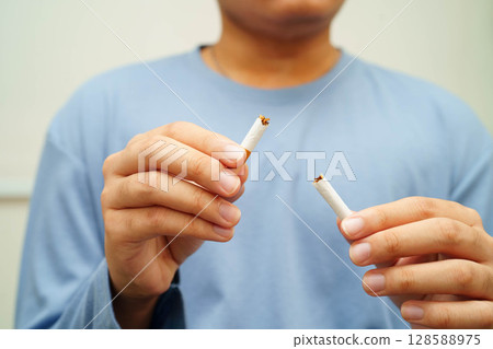 Quit smoking, Asian man breaking destroy cigarette in hand. Quit smoking, Asian man breaking destroy cigarette in hand. 128588975