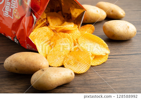 Bangkok, Thailand - May 15, 2022 Potato chips in open bag, delicious BBQ seasoning spicy for crips, thin slice deep fried snack fast food. 128588992