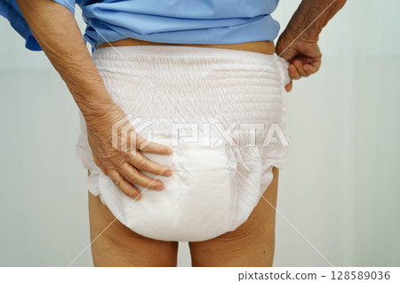 Asian senior woman patient wearing adult incontinence diaper pad in hospital. 128589036