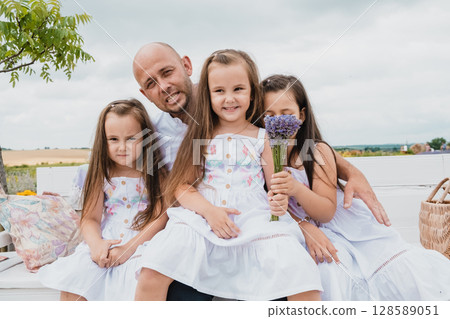 The family is resting on a retro bench in the lavender field The family is resting on a retro bench in the lavender field 128589051