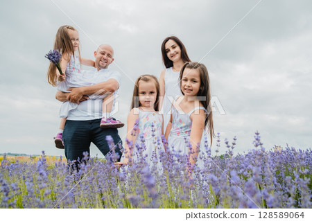 In the lavender field, a happy family enjoys a beautiful day 128589064