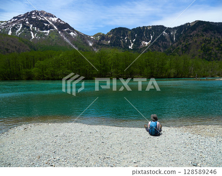 A male tourist taking a rest on the shore of Taisho Pond, a tourist spot in Kamikochi in summer A male tourist taking a rest on the shore of Taisho Pond, a tourist spot in Kamikochi in summer 128589246