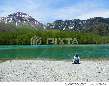 A male tourist taking a rest on the shore of Taisho Pond, a tourist spot in Kamikochi in summer 128589247